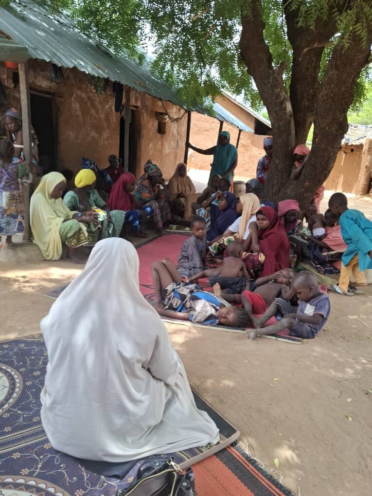 Women and children gathered outdoors during an Usmaniyya Academy community outreach visit